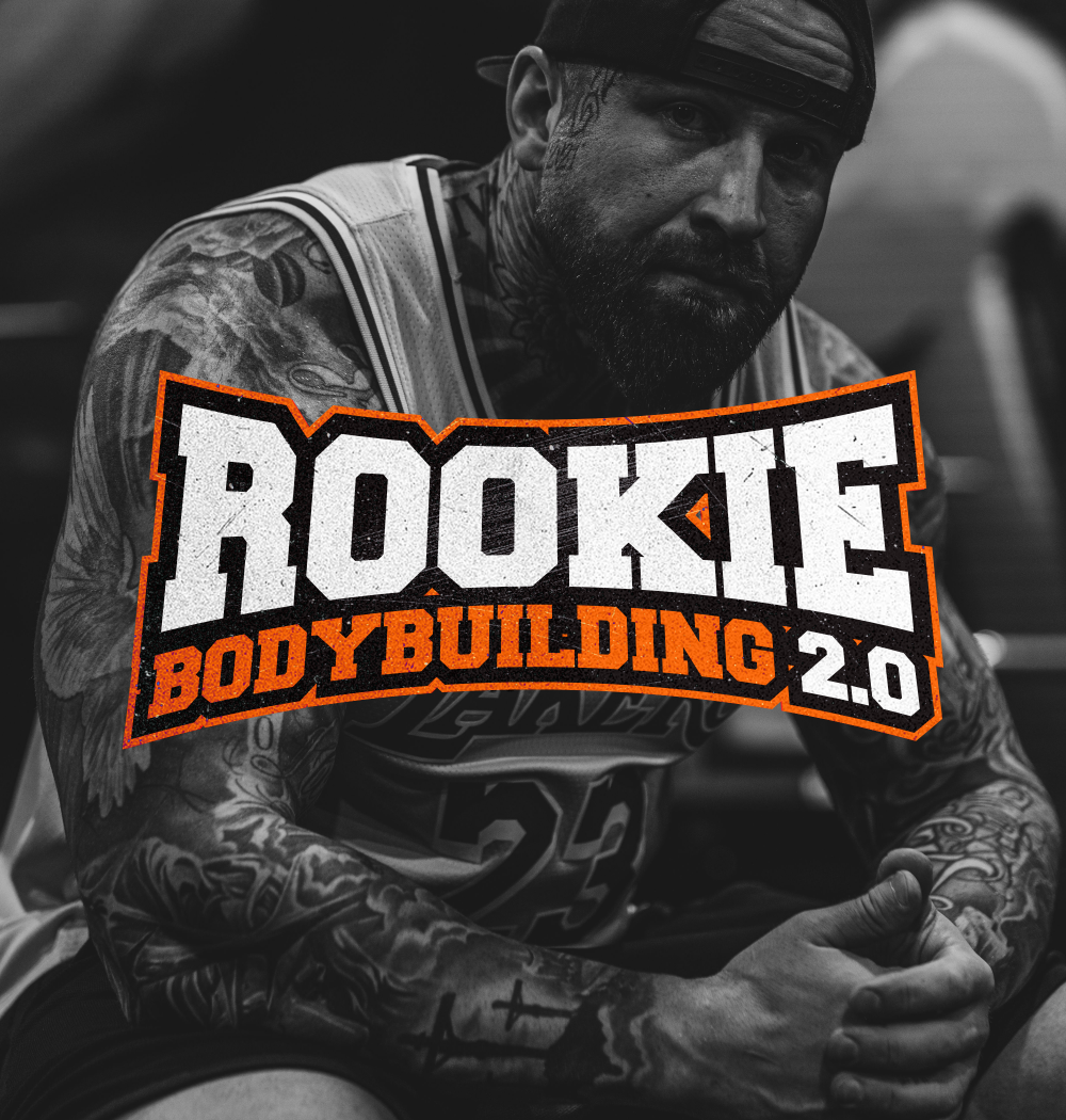 Tatuoitu mies istuu salilla – Rookie Bodybuilding 2.0 treeniohjelma aloittelijoille kehonrakennuksen alkuun.